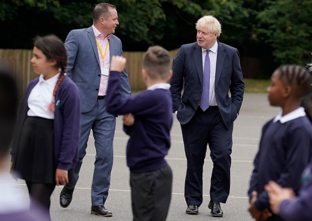 Boris Johnson and James Roach chat in the playground surrounded by Beechfield students